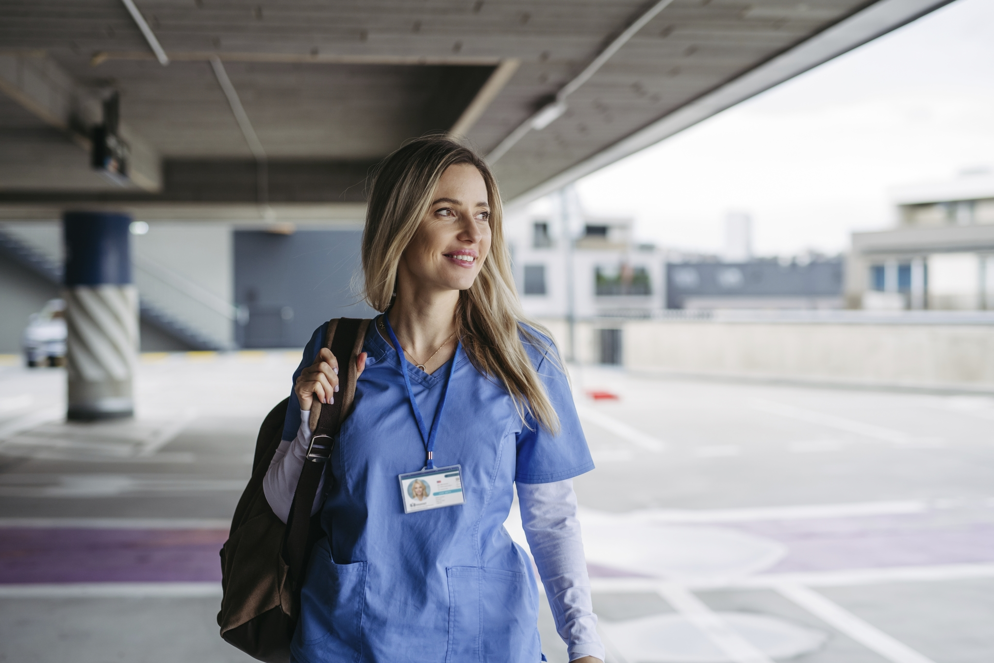 Travel nurse in scrubs with backpack ready for deployment
